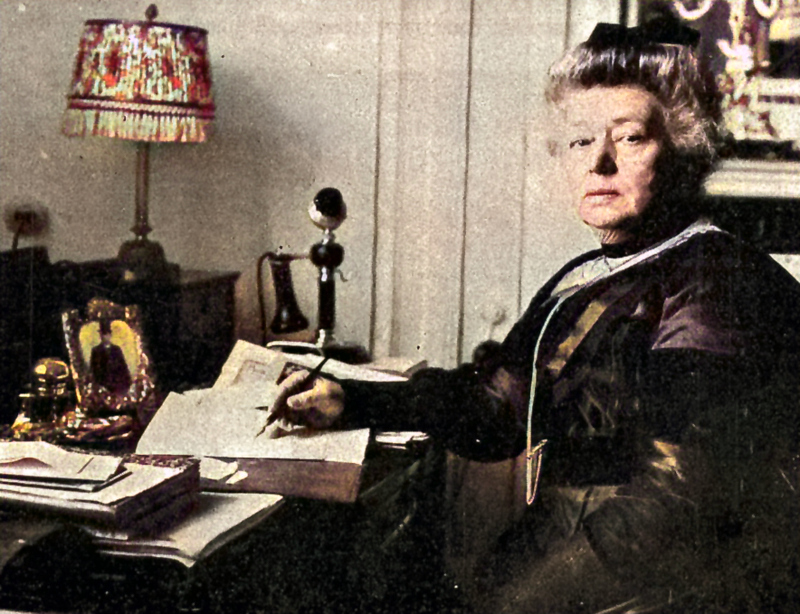 Bertha von Suttner am Schreibtisch, schreibend mit Feder